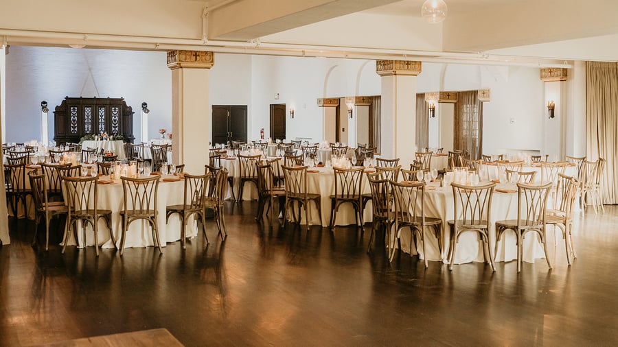Indoor banquet with ivory linens, crossback chairs, and hardwood flooring at Fillmore Chapel by Wedgewood Events