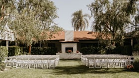 Outdoor garden ceremony site with stately white brick fireplace and lush greenery at Fillmore Chapel by Wedgewood Events